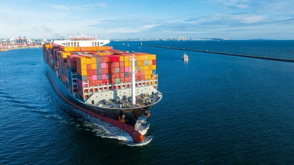Aerial view of a container ship adjusting course at sea during port call changes