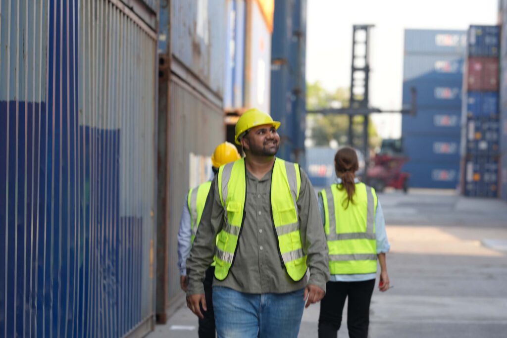 Port workers walking around busy port.