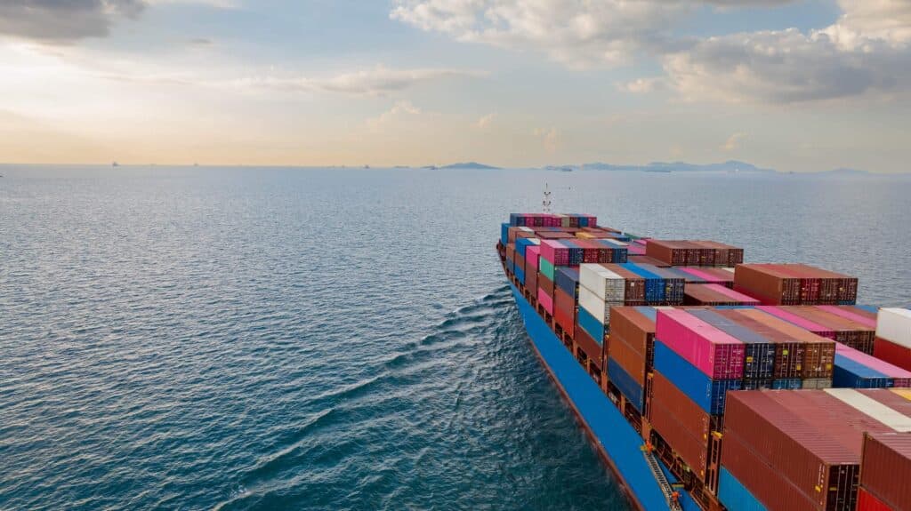 Container ship approaching port with full cargo load, illustrating how port tariffs apply to vessel calls and cargo volume