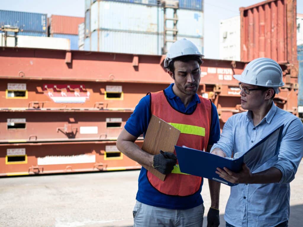 Port workers reviewing documents related to a charterparty agreement during cargo operations