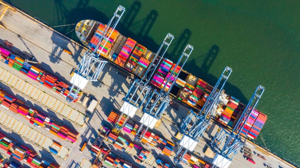 Aerial view of container ship loading cargo at terminal showing port call management in action