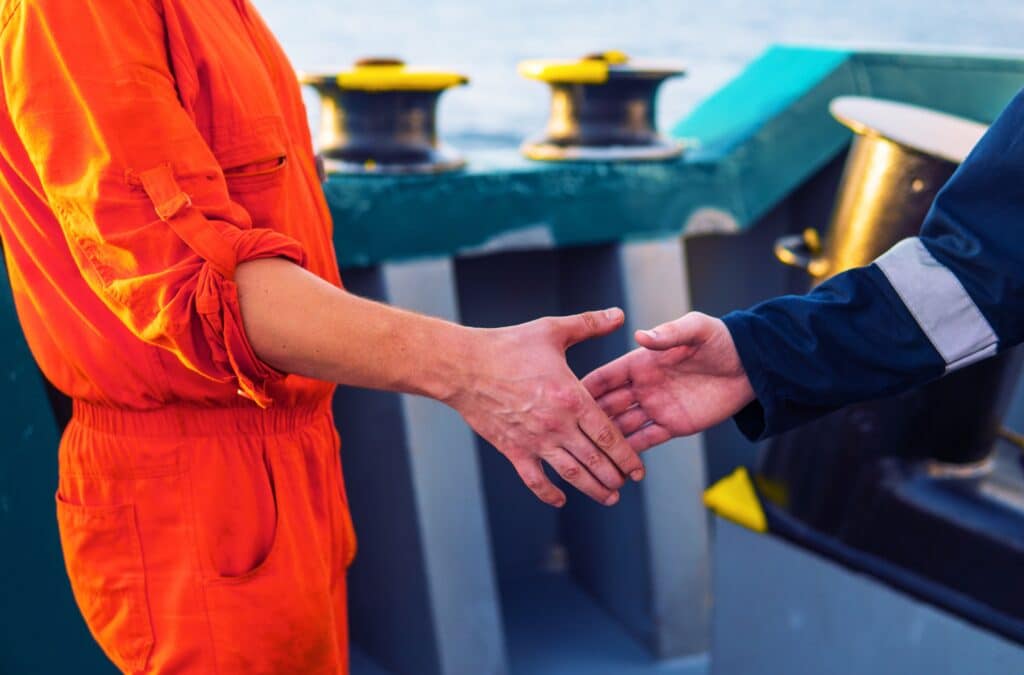 Handshake between maritime professionals finalizing a charterparty agreement at port