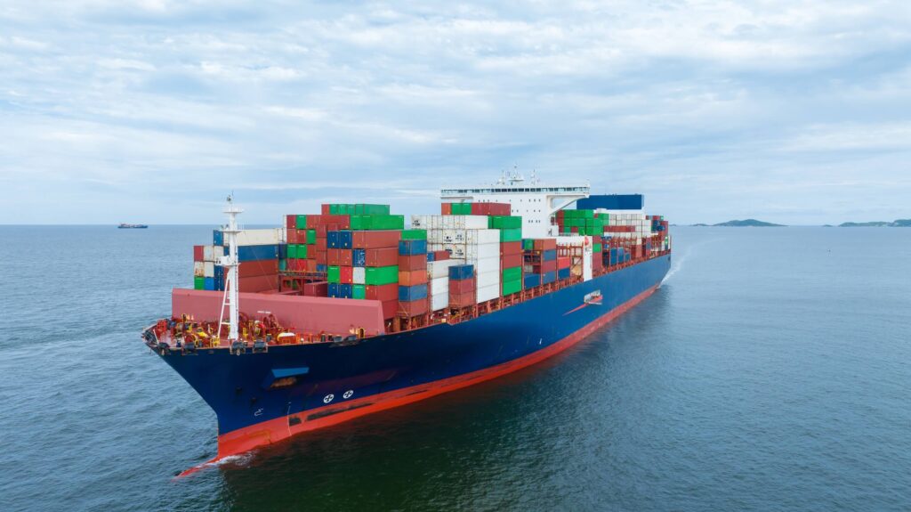 Cargo container ship at sea carrying freight with potential demurrage risk tied to port-call delays