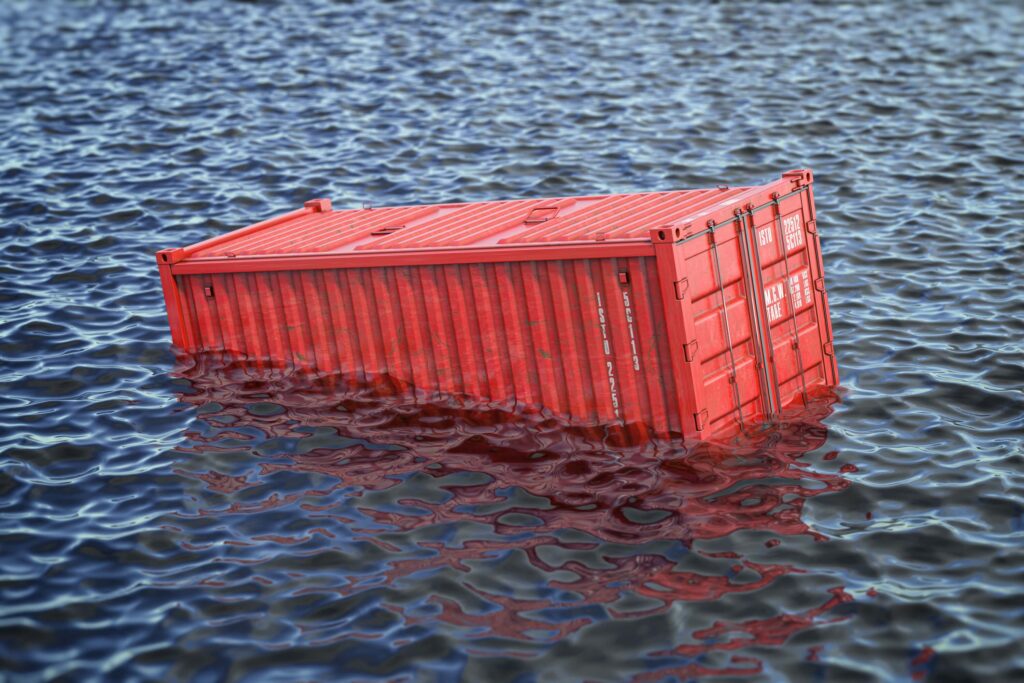 General average port call with a red shipping container floating partially submerged in the ocean