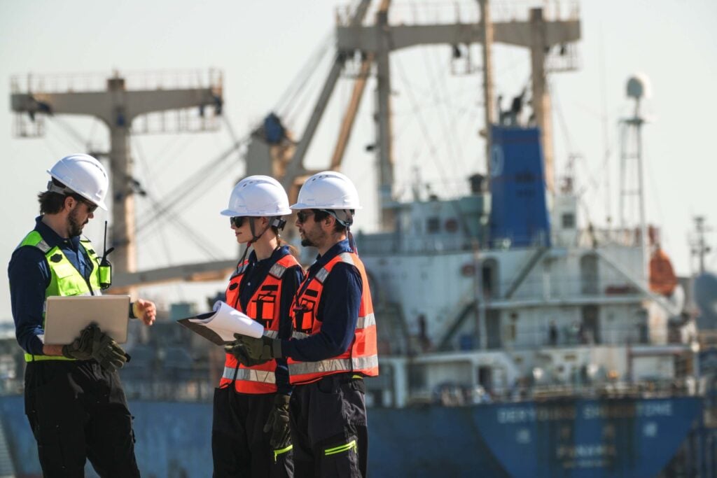 Port operations team coordinating vessel services, documents, and schedules for voyage management system vs port call software workflows.