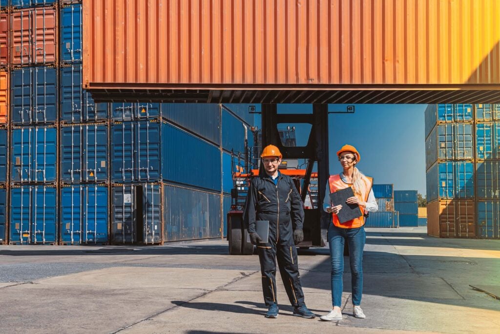 Port agent performance review at a container terminal with two logistics professionals holding operational documents