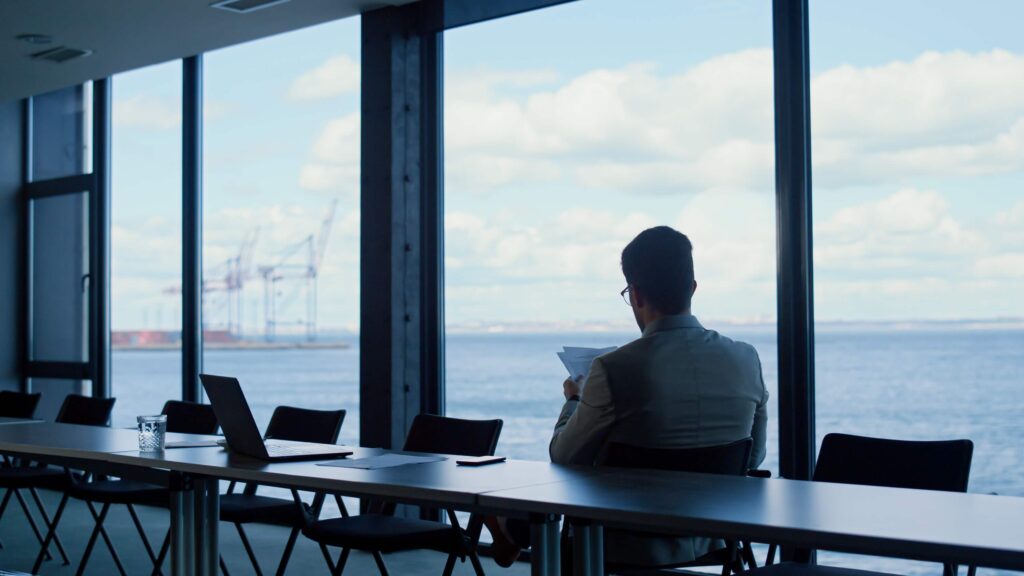 Maritime finance professional reviewing documents in a port office for QuickBooks for shipping companies
